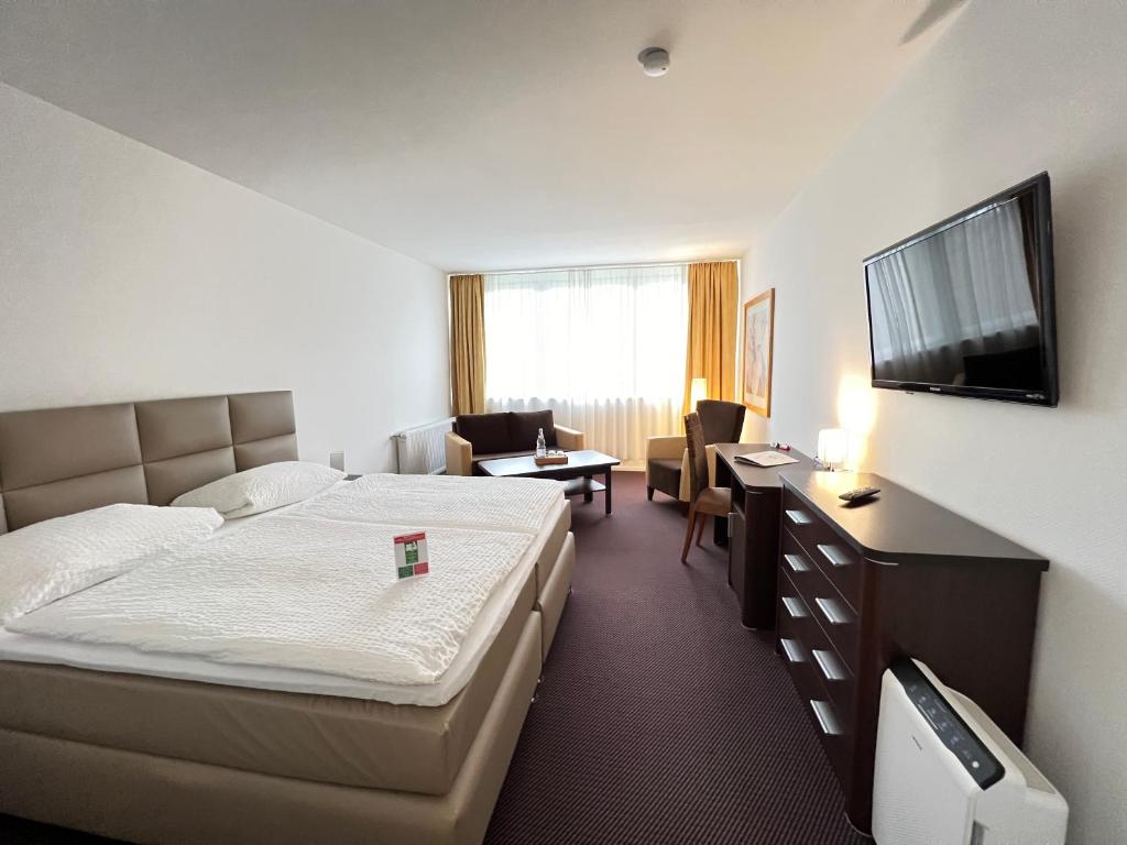 Cette chambre comprend un lit et un bureau. dans l'établissement Landhotel Weisses Ross garni, à Bad Brückenau