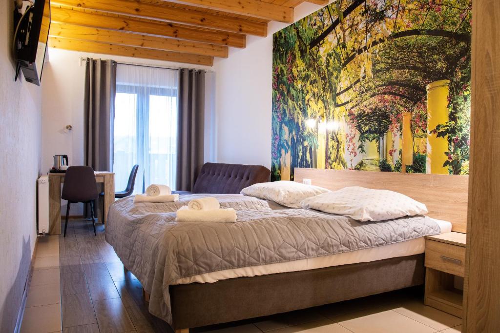 um quarto com uma cama grande e uma pintura na parede em URychertow em Kiełpino