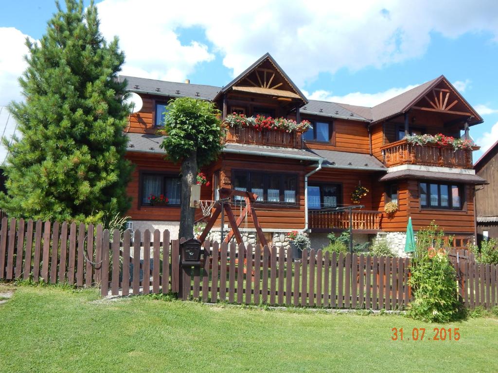 una casa de madera con una valla delante en Apartmán Lukáš, en Ždiar
