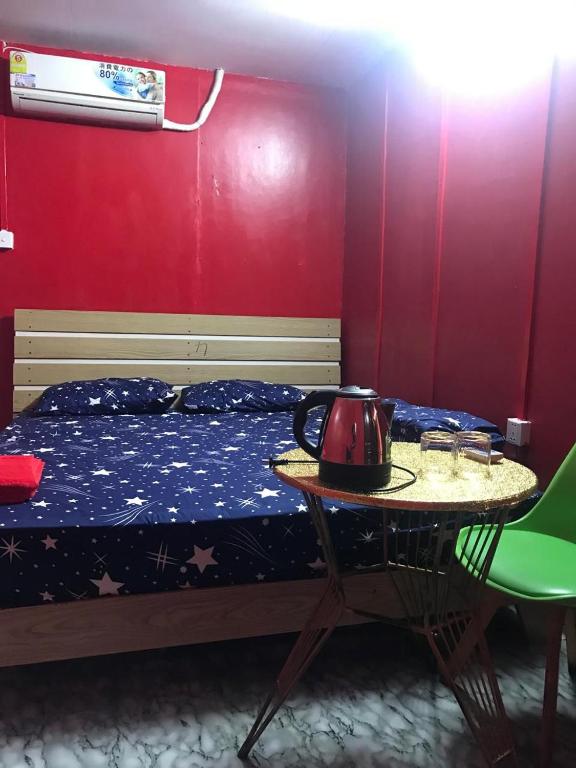 Un dormitorio con una cama y una mesa con un hervidor de agua. en The Big Boss Indian & Nepali Restaurant house, en Sihanoukville