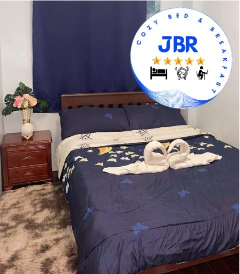 宿务JBR Cozy Bed & Breakfast的一间卧室配有一张带两个天鹅的床