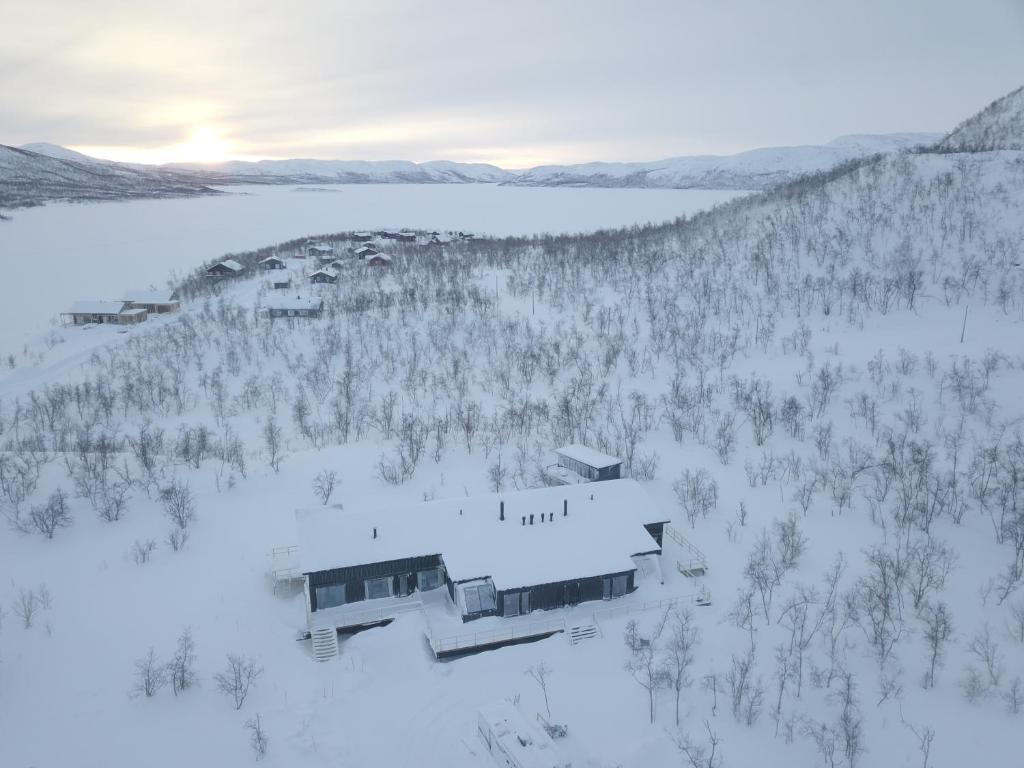 una vista aérea de una casa en la nieve en Sunrise View Lapland, Sky View Bedroom & Hot Tub en Kilpisjärvi