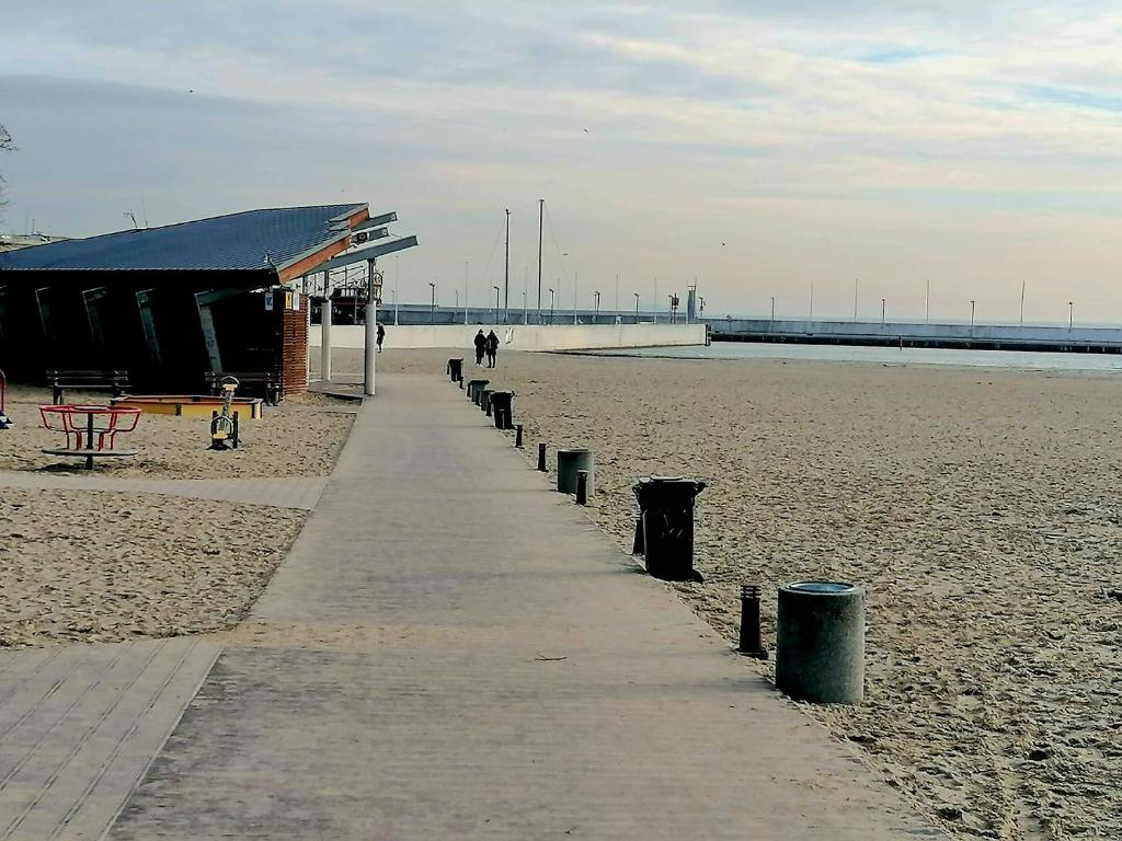 a path on a beach with a building on it at Gdynia Batory in Gdynia