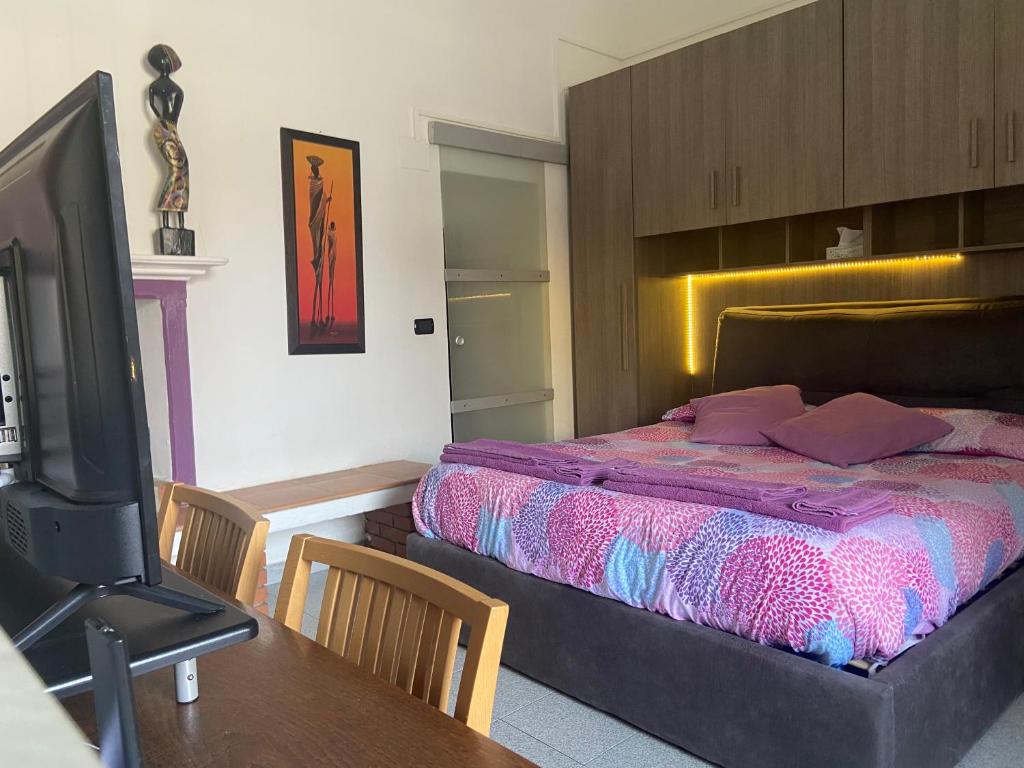 een slaapkamer met een bed en een tafel met een televisie bij Davide's House in Lomagna
