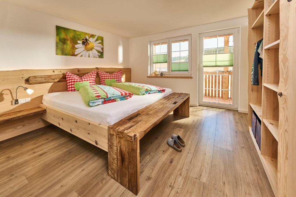 een slaapkamer met een houten bed met kussens bij Ferienhaus Wendelhof in Eisenbach