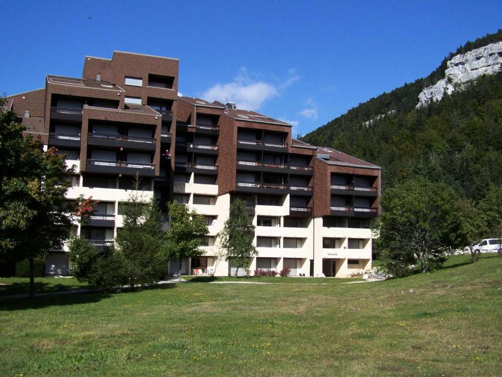 a large building with a grass field in front of it at Résidence Carette - Studio pour 4 Personnes 044 in Corrençon-en-Vercors