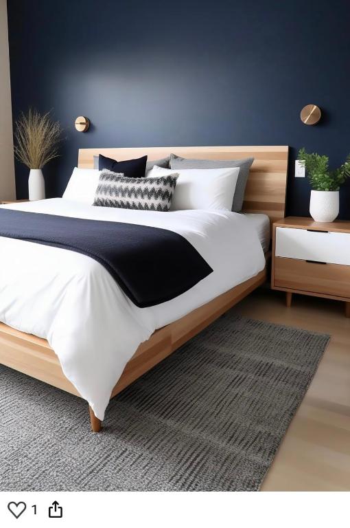 - une chambre dotée d'un grand lit avec des draps blancs et noirs dans l'établissement Route du Mont-Saint-Michel, à Mortain