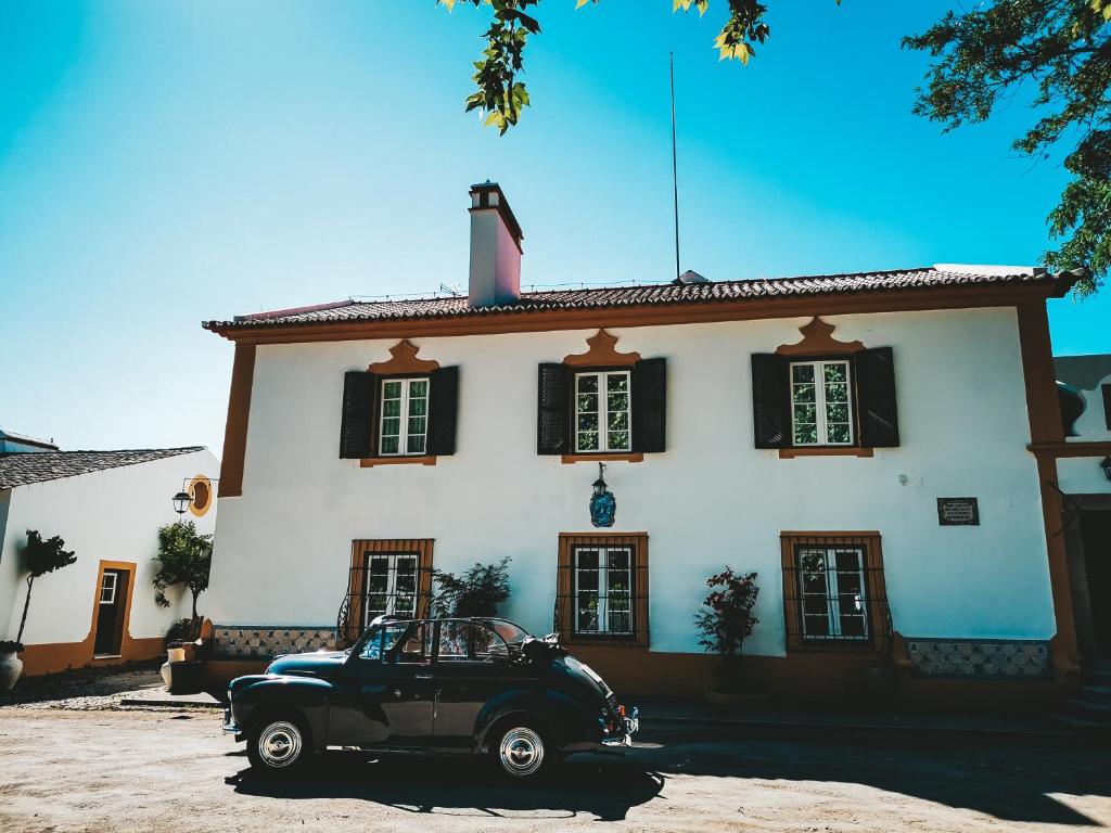 um carro preto estacionado em frente a um edifício em Quinta do Louredo - Évora em Évora