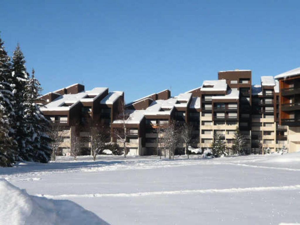 ein großes Gebäude mit Schnee auf den Dächern im Schnee in der Unterkunft Résidence Tiolache - Studio pour 4 Personnes 154 in Corrençon-en-Vercors