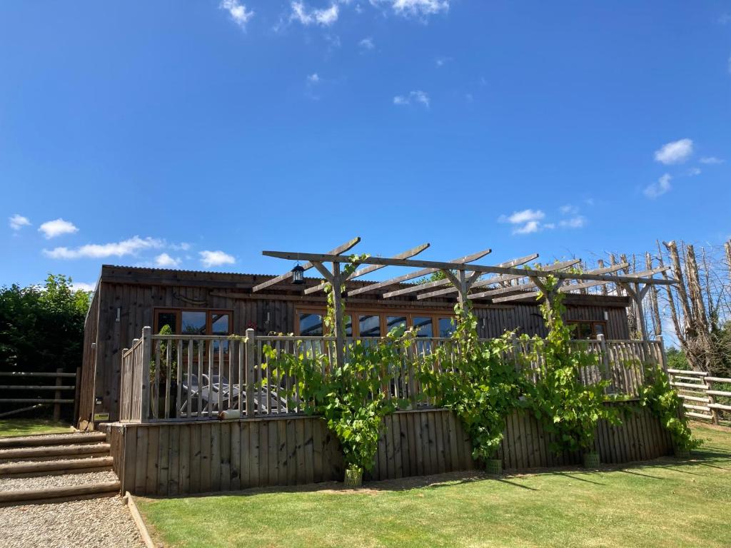a wooden house with a fence and some plants at Unique Private Lodge in Cornwall sleeps 4 