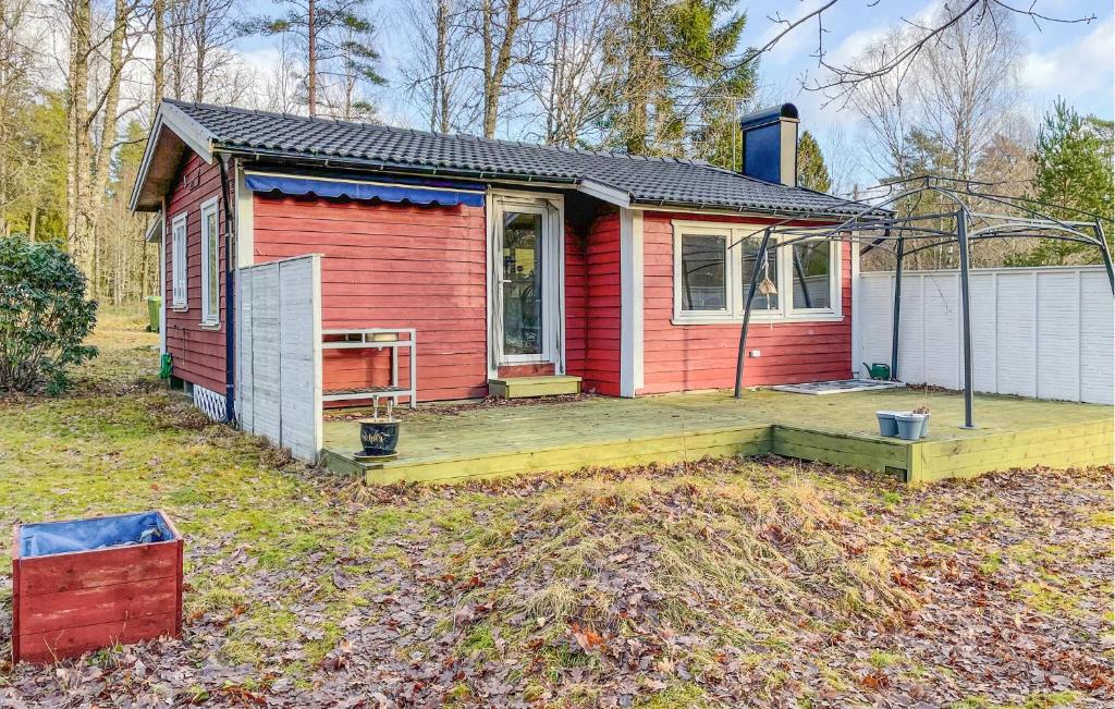 a small red house with a deck in the yard at Lovely Home In Lnghem With Kitchen in Länghem