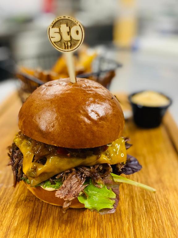 a sandwich on a wooden cutting board with a sign on it at Hotel 100 in Pardubice