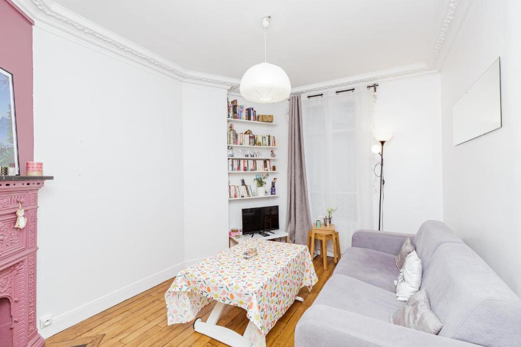 ein Wohnzimmer mit einem Sofa und einem Tisch in der Unterkunft Charming Bright Apt In Paris in Paris