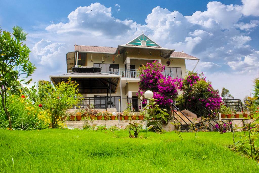 a house with flowers in front of a yard at Blue Lake in Kanthalloor