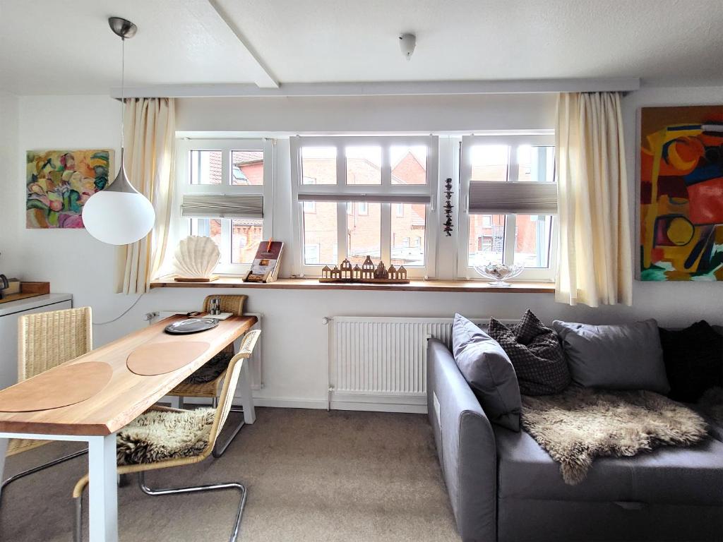 ein Wohnzimmer mit einem Sofa und einem Tisch in der Unterkunft Inselresidenz Strandburg - Ferienwohnung 210 (Ref. 50967u2) in Juist