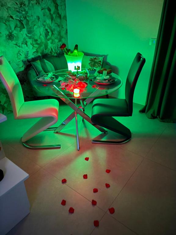 una camera verde con tavolo e sedie con cuori sul pavimento di Infinity Suite a Peschici