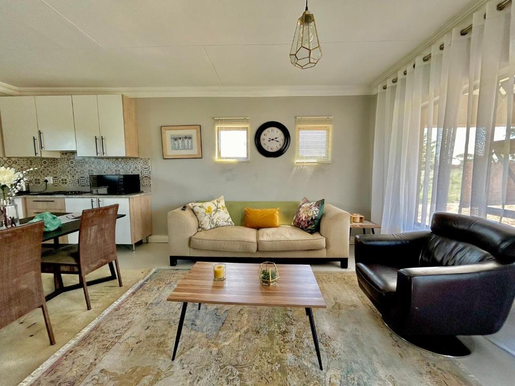 uma sala de estar com um sofá e uma mesa em The Comfy Corner @ Skyfall Country Estate em Polokwane