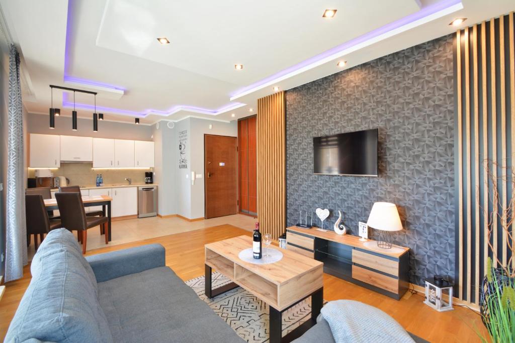 ein Wohnzimmer mit einem Sofa und einem Tisch in der Unterkunft Apartamenty Aquamarina SeaView by Rent like home in Misdroy