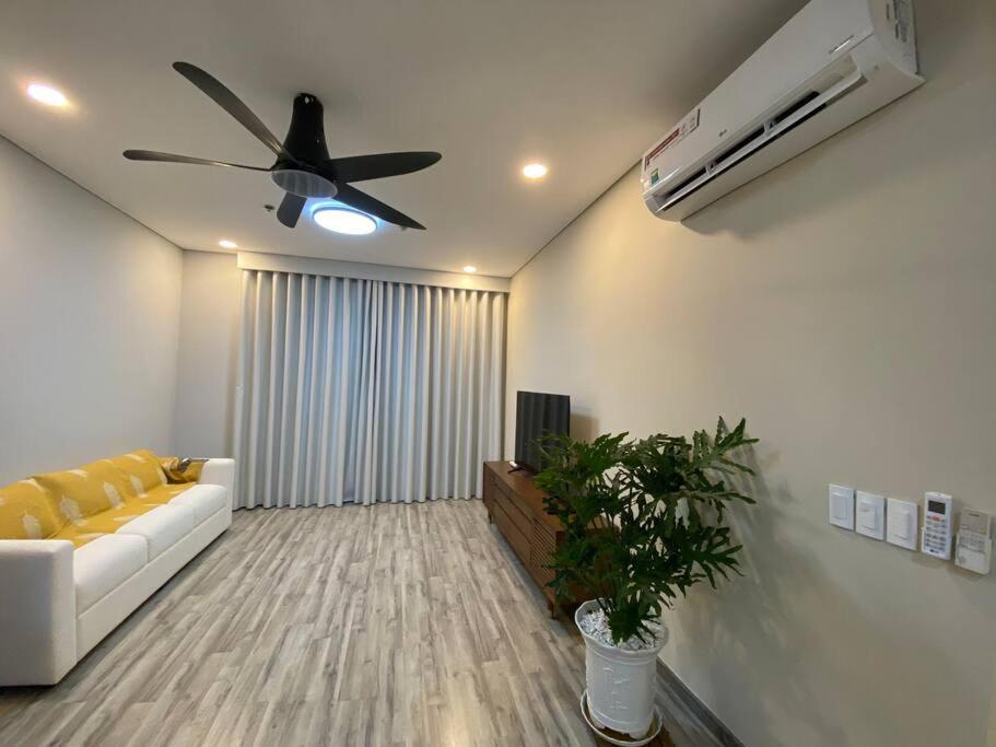 uma sala de estar com um sofá branco e uma ventoinha de tecto em Sora Gardens 1 em Xóm Bưng Ðìa