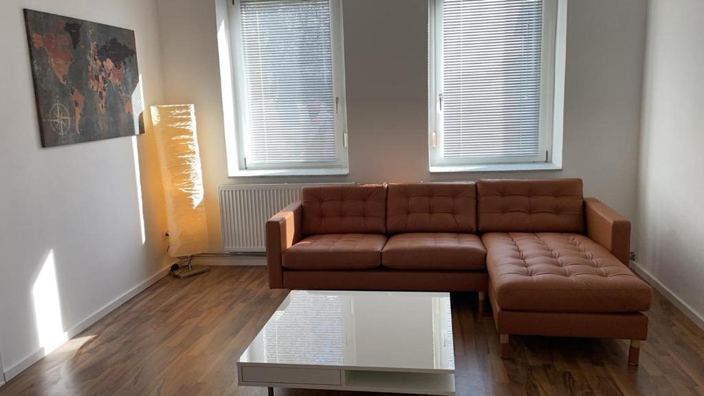 - un salon avec un canapé brun et une table en verre dans l'établissement Große Wohnung, à Magdebourg