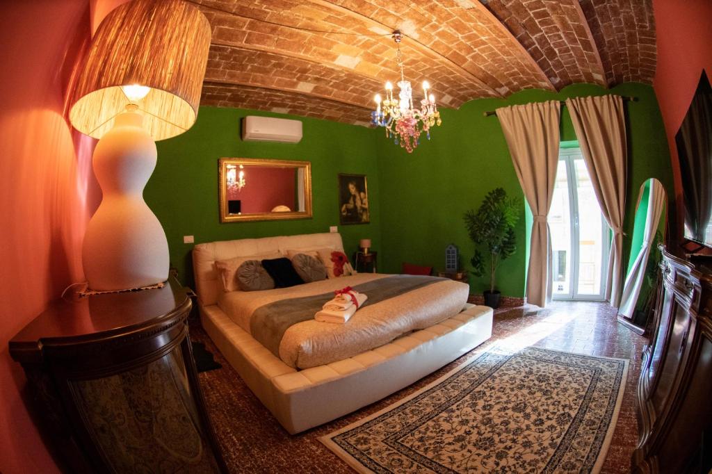 ein Schlafzimmer mit einem Bett in einem Zimmer mit grünen Wänden in der Unterkunft Casita Jolanda in Albano Laziale
