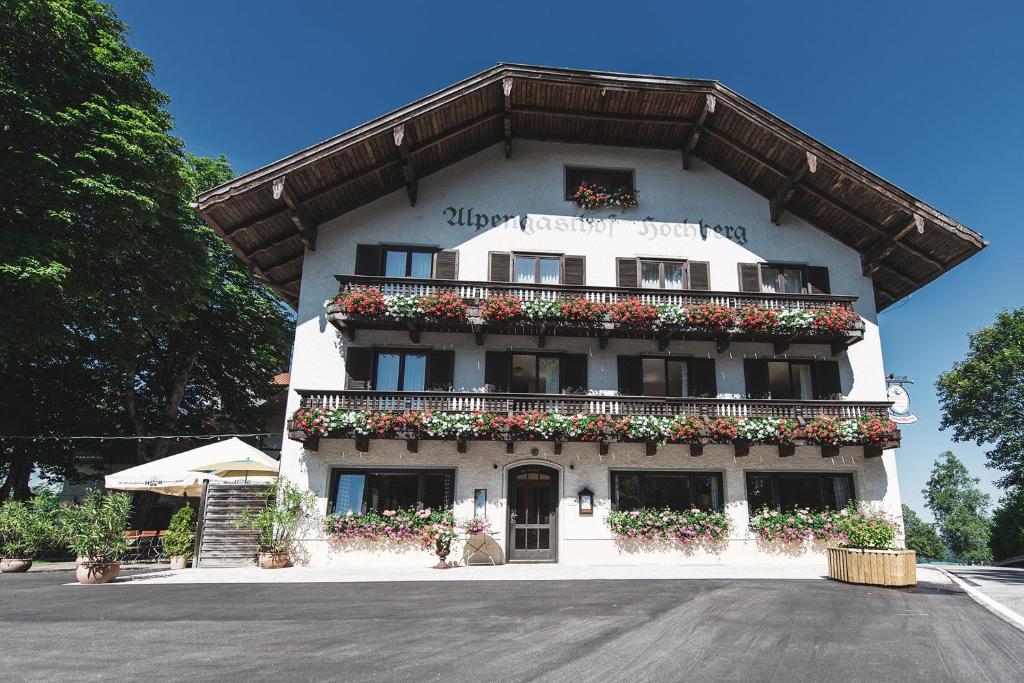 um grande edifício branco com caixas de flores em Alpengasthof Hochberg - Familie Gruber em Traunstein