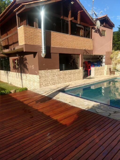 a house with a swimming pool in front of a house at Chácara em Ibiúna com piscina e acesso a represa in Ibiúna