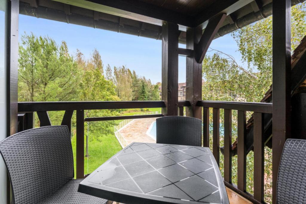 a patio with a table and chairs on a deck at La Résidence du Golf - maeva Home - Appartement 2 pièces 5 personnes - Conf 74 in Deauville