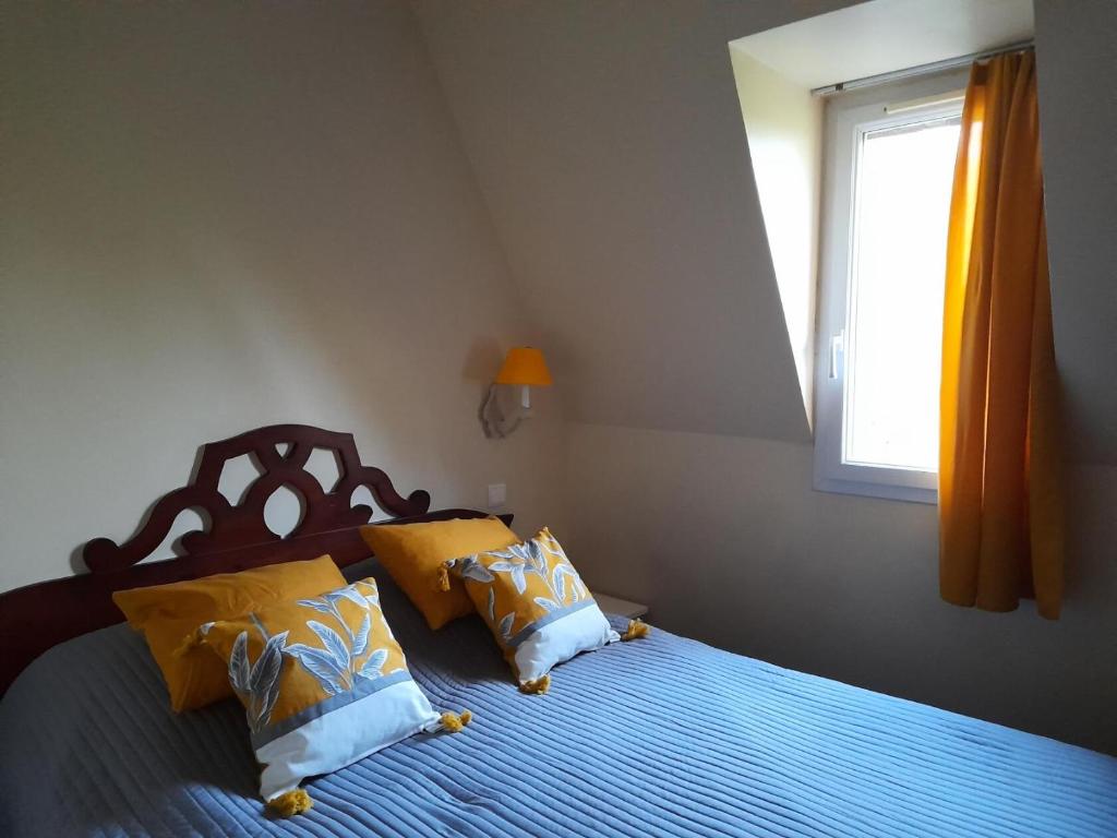 a bedroom with a bed with yellow pillows and a window at La Résidence du Golf - maeva Home - Appartement 2 pièces 5 personnes - Conf 74 in Deauville