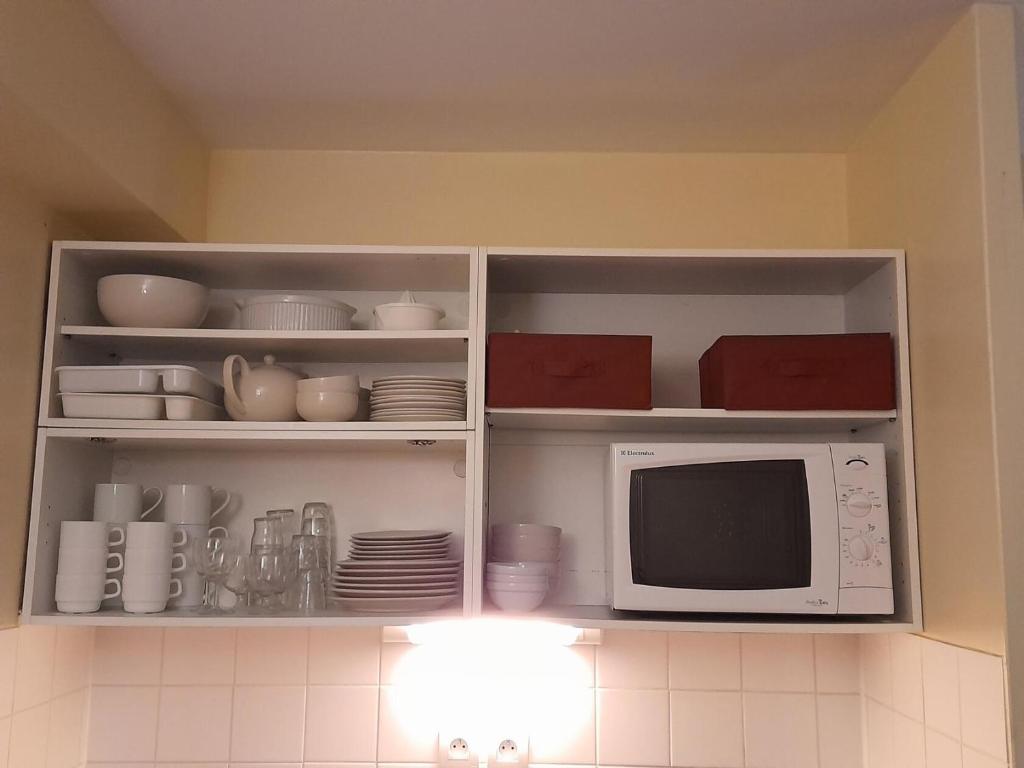 a kitchen with a microwave and plates and dishes at La Résidence du Golf - maeva Home - Appartement 2 pièces 5 personnes - Conf 74 in Deauville