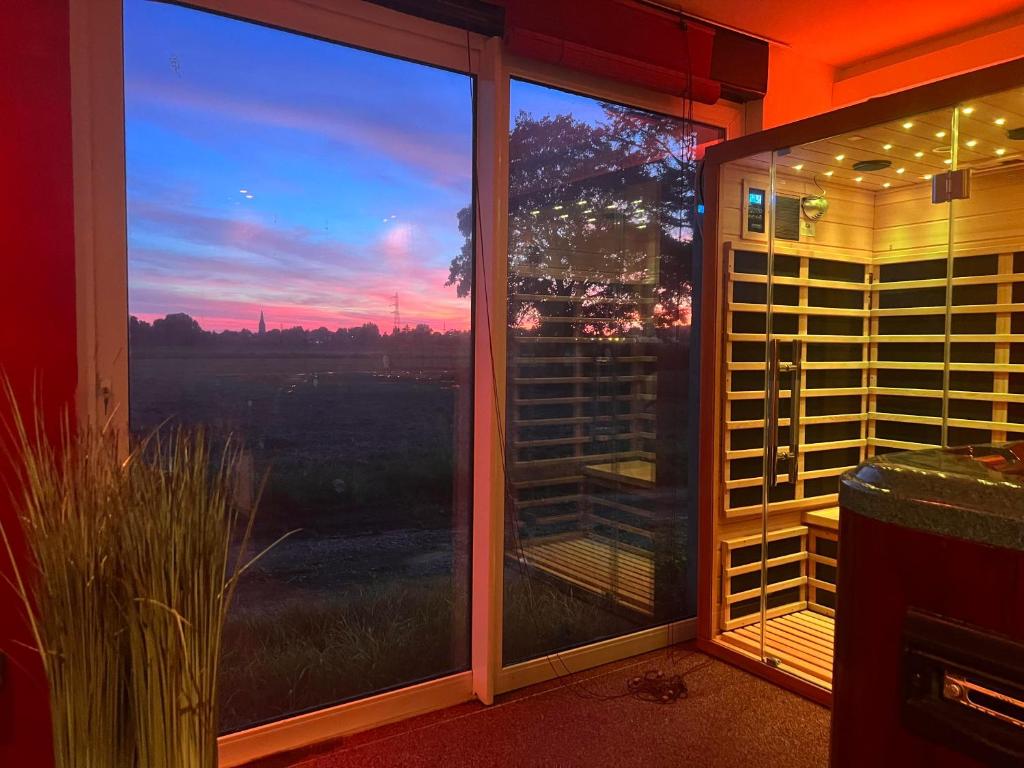a room with a window with a view of a sunset at Loft Spa La Maison du Bambou in Sequedin