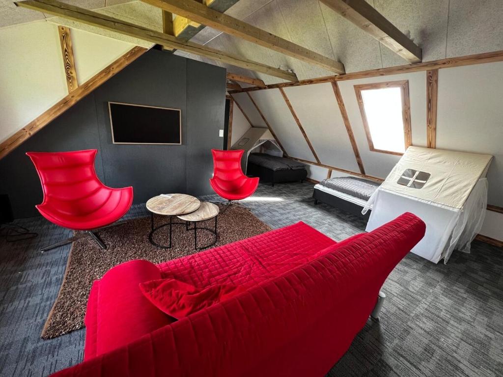 a living room with a red couch and red chairs at Family Apartment - Near Billund in Randbøldal