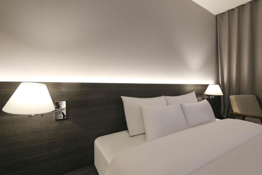 Postel nebo postele na pokoji v ubytování H Avenue Hotel Sangmu Branch