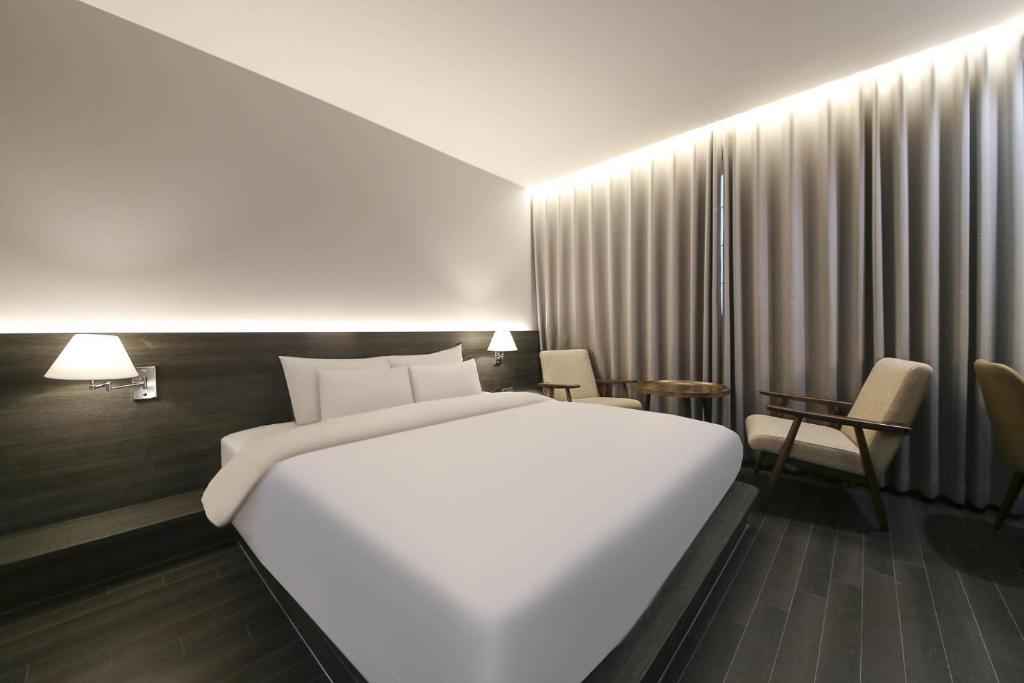 Postel nebo postele na pokoji v ubytování H Avenue Hotel Sangmu Branch