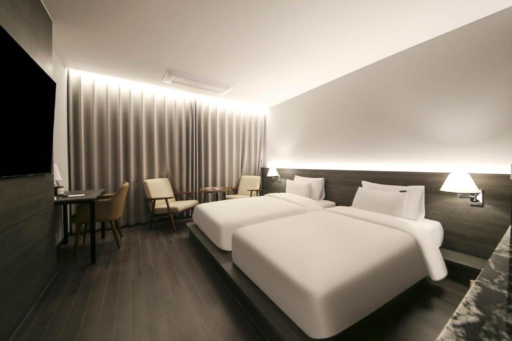 Postel nebo postele na pokoji v ubytování H Avenue Hotel Sangmu Branch