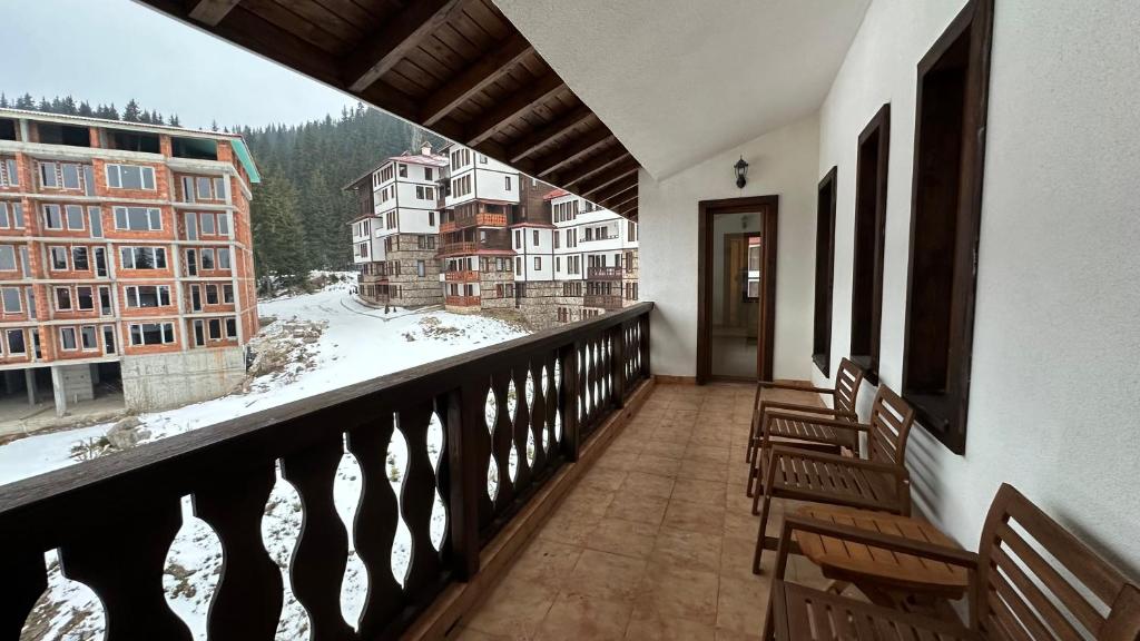 een balkon met stoelen en uitzicht op een berg bij Апартаменти и стаи за гости "Алекс" in Pamporovo
