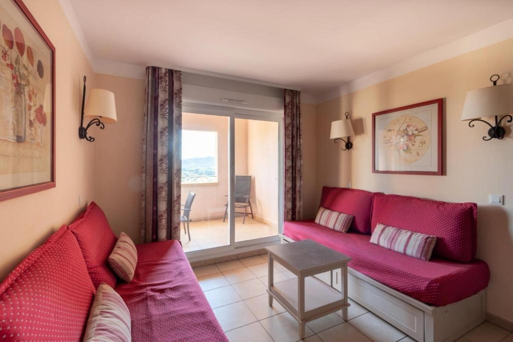 - un salon avec un canapé rouge et une fenêtre dans l'établissement Les Coteaux de Pont Royal en Provence - maeva Home - Appartement 2 Pièces 4 Personnes - Confort MAE-5993, à Mallemort