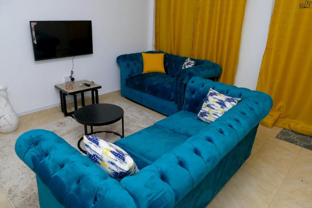 a living room with a blue couch and a table at Saas Homestay in Eldoret