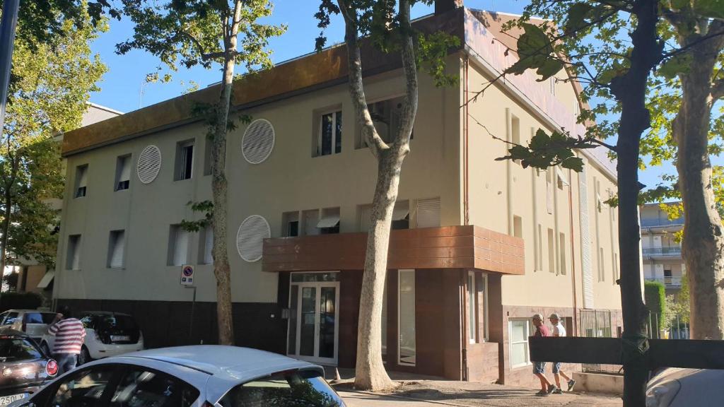 a building with a car parked in front of it at Residence Appartamenti Casa Vacanze Abbazia in Pesaro