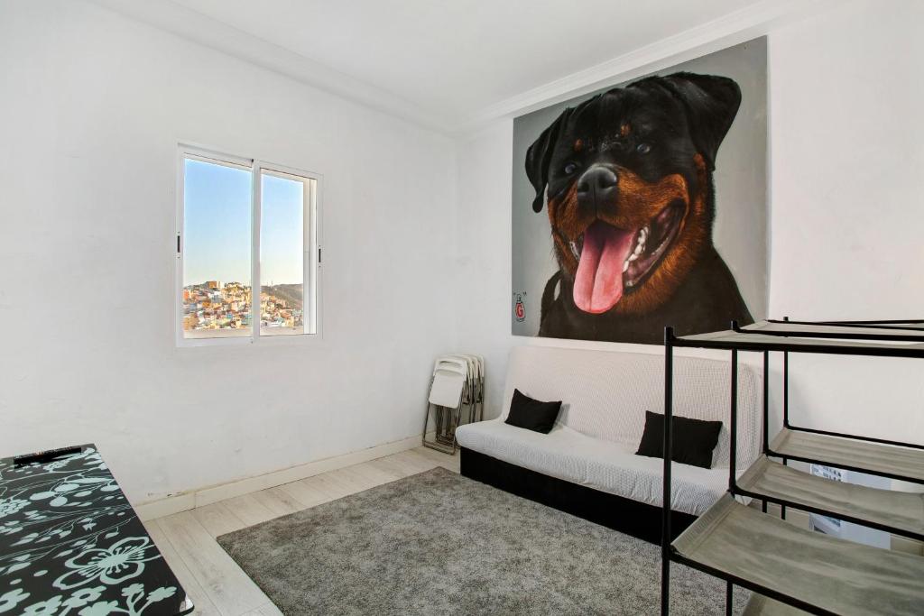 a living room with a painting of a dog on the wall at Cristobal y concha in Las Palmas de Gran Canaria