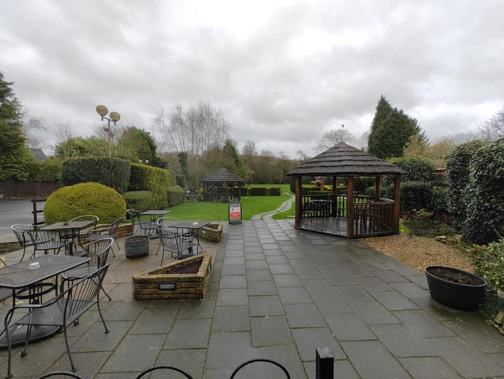 a garden with a gazebo and tables and chairs at The Golden Cup - Yoxall in Yoxall