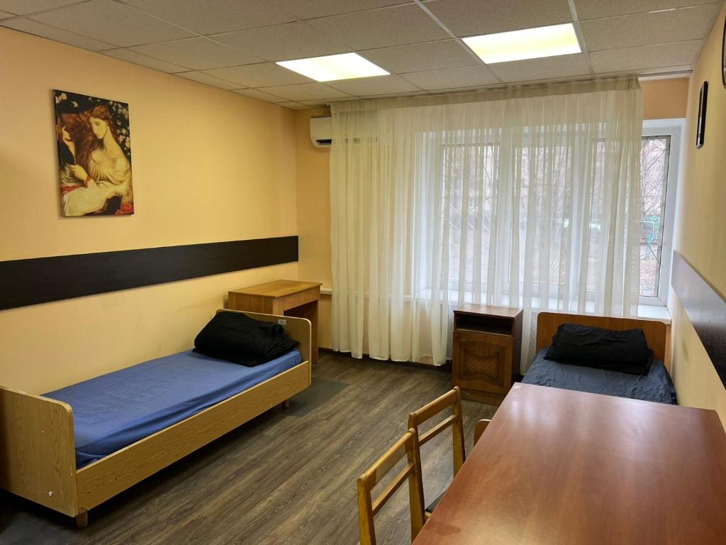 a room with two beds and a table in it at Hostel Krone GOK Zatishok in Kyiv