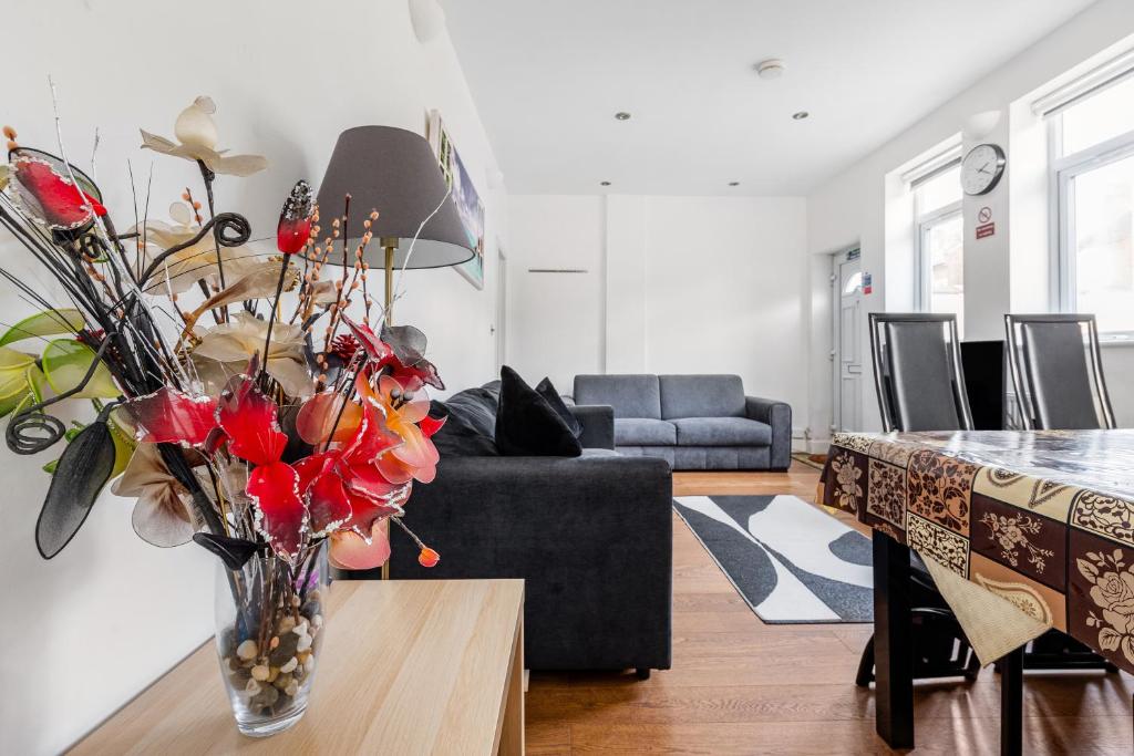 uma sala de estar com um vaso de flores sobre uma mesa em Spacious 2 bed Apartment with FREE PARKING for 2 cars and underground station Zone 2 for quick access to Central London up to 8 guests em Londres