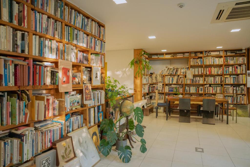 a library with many shelves of books and a table at Motif No.1 Guest House in Paju