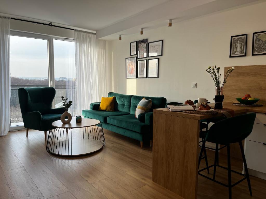 sala de estar con sofá verde y mesa en Apartament Letnica Latarników Family Seaside, en Gdansk