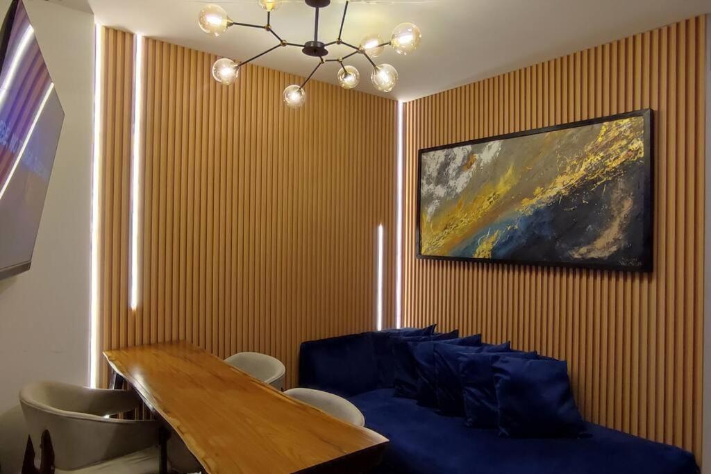 a dining room with a table and a painting on the wall at DEPARTAMENTO EN EQUIPETROL CON PISCINA - GYM Y PARQUEO GRATIS, CERCA DEL VENTURA MALL , LOS TAJIBOS, MANZANA 40 Y SUPERMERCADOS in Santa Cruz de la Sierra