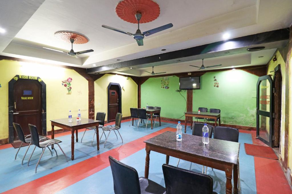 a dining room with tables and chairs and green walls at OYO Flagship Hotel Shreya in Bhubaneshwar