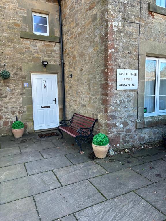 a bench sitting in front of a building with a door at Last Cottage in Richmond