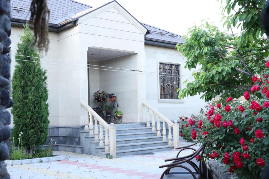 una casa blanca con escaleras y flores en Sargsyan’s House en Gyumri