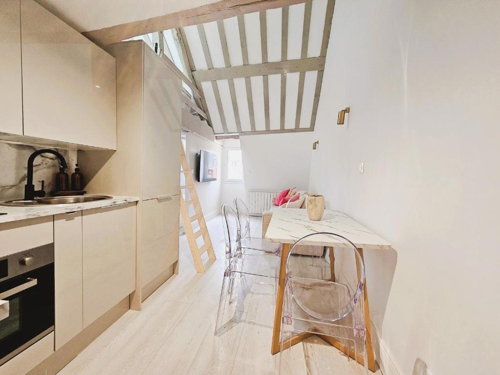 une cuisine avec une table et des chaises dans une pièce dans l'établissement Suite Cathédrale haut de gamme + Parking - N°8, à Rouen